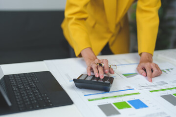 Businesswoman is calculating financial results and analyzing charts and graphs at her desk. Company performance startup business idea.
