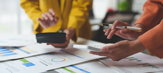 Businesswoman is calculating financial results and analyzing charts and graphs at her desk. Company performance startup business idea.