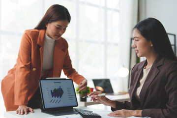 Startup business idea Businesswoman, management team, administration, pointing at chart on laptop and explaining strategy Discuss with the team to analyze financial business growth.