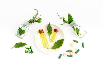 Alternative herbal medicine concept with healing herbs and essential oil in glass bottles