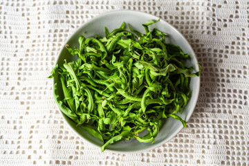 Getrocknete Zitronenstrauch Blätter in einer hellen Schüssel abgegezupft zu Hause in der Küche