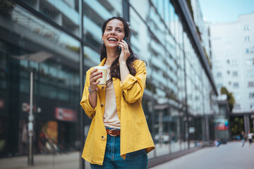 Happy Woman Talking on Phone Holding Coffee Outdoors