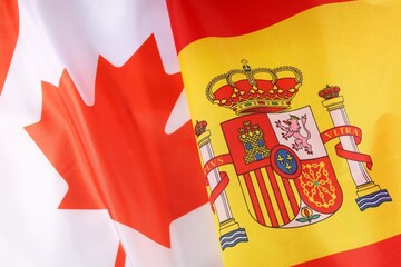 Canadian and Spanish flags displayed together during a cultural event
