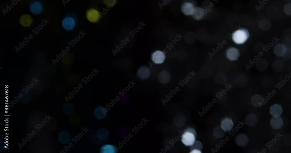 Poster shot of blurry effect of round shiny objects in black background.