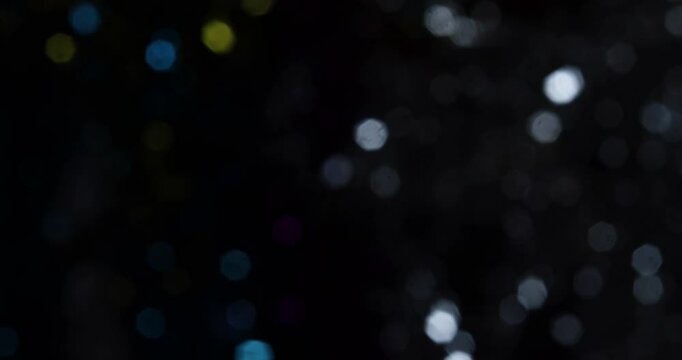 Shot of blurry effect of round shiny objects in black background.