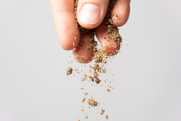 Hand pouring ground peppercorn mixture, black, white, red and green pepper