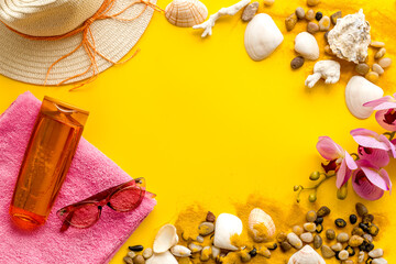 Summer beach background with shells and sea sand with sunbathe accessories, top view