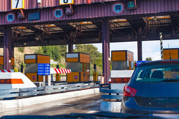 Toll station in Portugal. Cars crossing toll road gates at sunny summer day