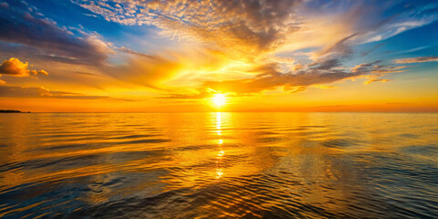 Obraz premium Golden sunset over a calm sea, clear weather, warm glow on the horizon