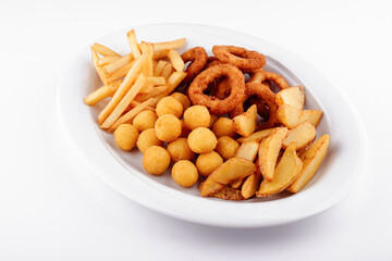 Big plate of french fries, potato wedges, onion rings and croquettes on white background
