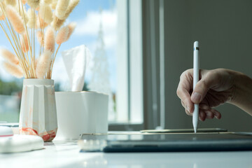 Hand using digital stylus writing on tablet. Concept of digital signature Signing documents...