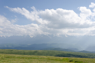 Mountain slopes with clouds on the sky covered with valley on top and mountains in Altay Russia early in the evening sunset. Hight quality horizontal photo