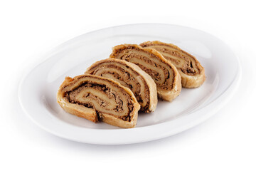 Poppy seed roll slices lying on white plate isolated on white background