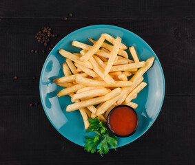French fries lying on blue plate with ketchup and parsley