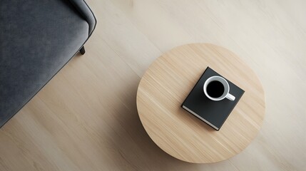 A top-down view of a simple, modern coffee table with a single book and a cup