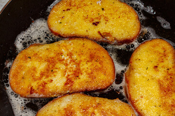 Fry bread croutons in egg in a frying pan