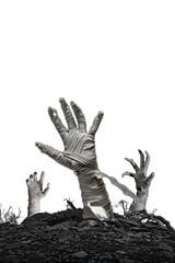 Mummy's hands wrapped in a bandage creepily moving reaches up through the ground grave on isolated...