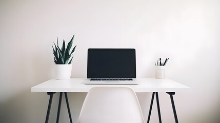 A minimalist workspace with a clean desk, a laptop, and a simple chair