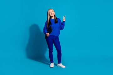 Full body length photo of young model chinese woman in sweater and jeans posing v sign with laptop...