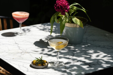 Martini glass cocktails served on restaurant table. Margarita and Cosmopolitan cocktail with olive
