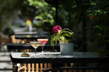 Martini glass cocktails served on restaurant table. Margarita and Cosmopolitan cocktail with olive