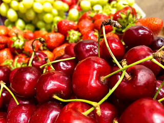 Cherries, strawberries and grapes on a wooden background. Selective focus