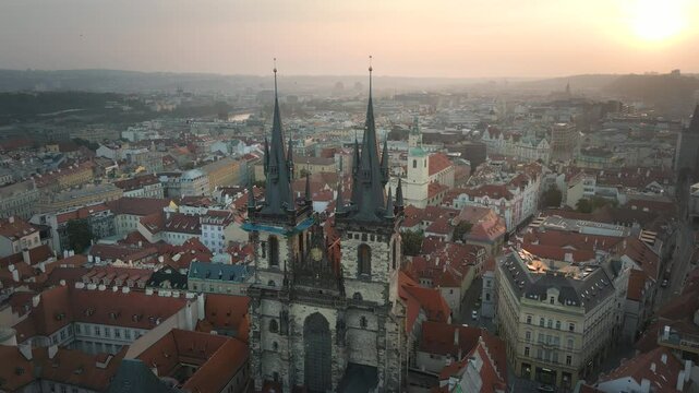 Aerial Drone. Beautiful Ancient Gothic Church in the Square in Prague Old City at sunset. Awesome View of the Antique Traditional Praha Houses. Prague cathedral aerial skyline view.