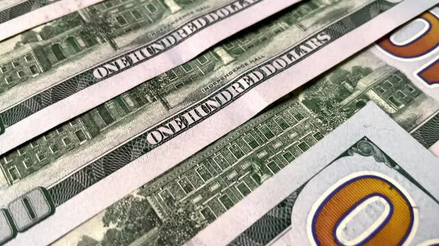 Colorful background backdrop of US hundred dollar banknotes scattered on surface, financial counting, expenses, wealth concept, financial planning, investing.