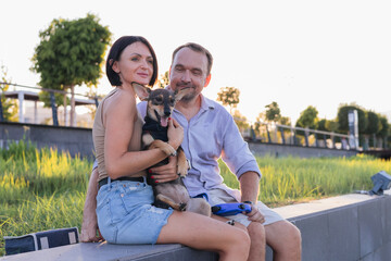 A happy smiling couple walking, hugging and kissing in park on late summer sunset