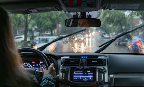 Woman driving while it's raining on a city street