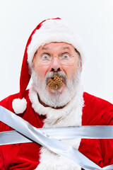 With pinecone in his mouth, Santa sits bound in duct tape, looking bewildered and motionless, his...
