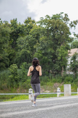 Obraz premium young Asian woman wears sports bra and running shoes to go jogging every morning for her health because running can help her body burn extra energy. Health running concept for the body.