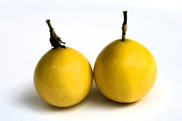Two matured yellow passion fruit, Passiflora edulis, white background, Thiruvananthapuram, Kerala,...