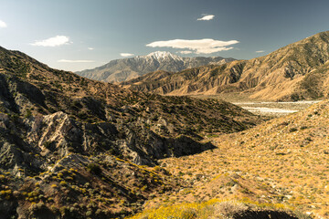 A mountain range with a cloudy sky in the background