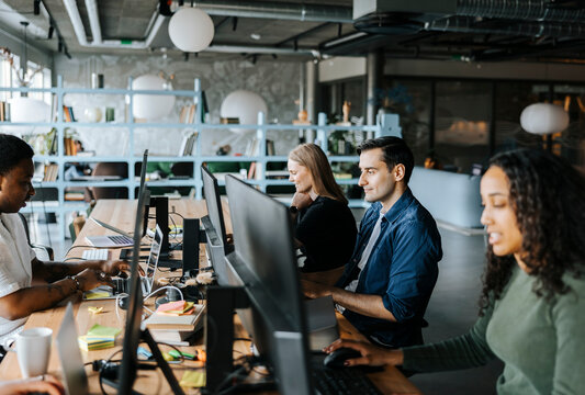 Male and female programmers coding while sitting in tech startup office