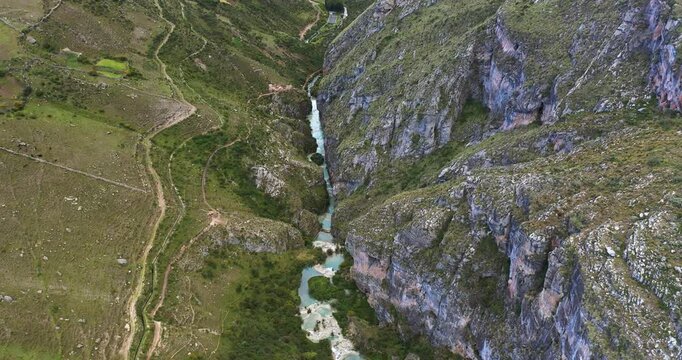 Beautiful slow motion drone shot of a beautiful lake between mountains with turquoise waters called Millpu in Ayacucho, Peru.