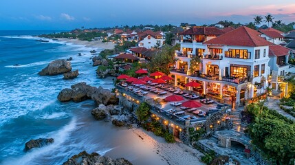 Obraz premium Oceanfront restaurant with red umbrellas at sunset, creating a serene dining atmosphere.