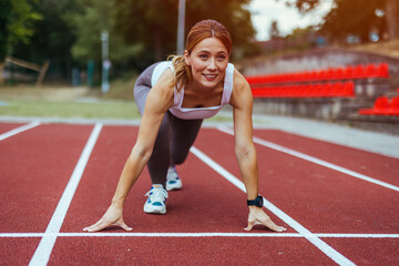Athletic Woman Ready to Start Running on Track Field