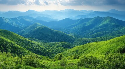 Fototapeta premium Lush green mountains stretching across the horizon under a cloudy sky during late morning in a tranquil valley
