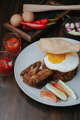 Food And Drink Photography For Restaurant Or Cafe Business. Nasi goreng, traditional Indonesian food. Freid rice serving with eggs and shrimp crisp on white plat. Top view