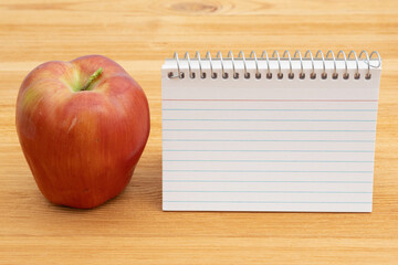 Back to School with a blank notebook and apple on a desk