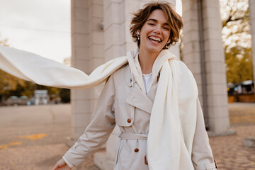 pretty smiling woman walking in park in winter clothes