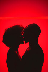 A couple kissing in a red background