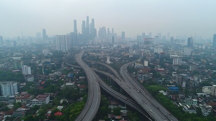 Aerial view of a bustling cityscape shrouded in mist with highways and skyscrapers.