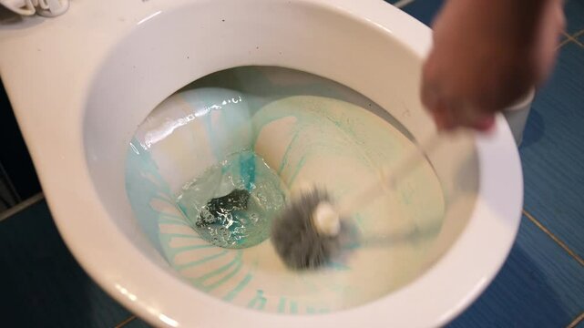 A dirty toilet is cleaned by applying gel chemicals and scrubbing with a brush.