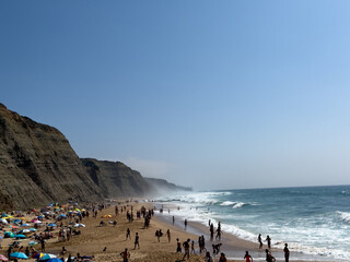 A perfect day at the beach with clear blue skies and crashing waves