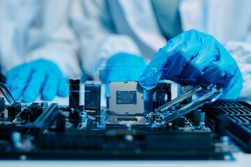 The technician is putting the CPU on the socket of the computer motherboard. electronic engineering...
