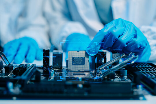 The technician is putting the CPU on the socket of the computer motherboard. electronic engineering electronic