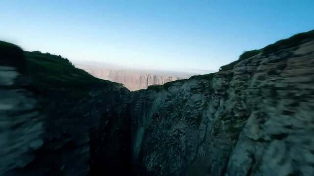 Captivating views unfold as a camera sweeps across a rugged cliff, unveiling an expansive landscape adorned with mountains, valleys, and striking geological formations