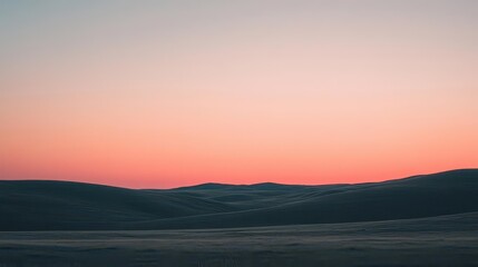 Obraz premium A tranquil countryside scene at sunset, with rolling hills under a sky painted in shades of pink and orange